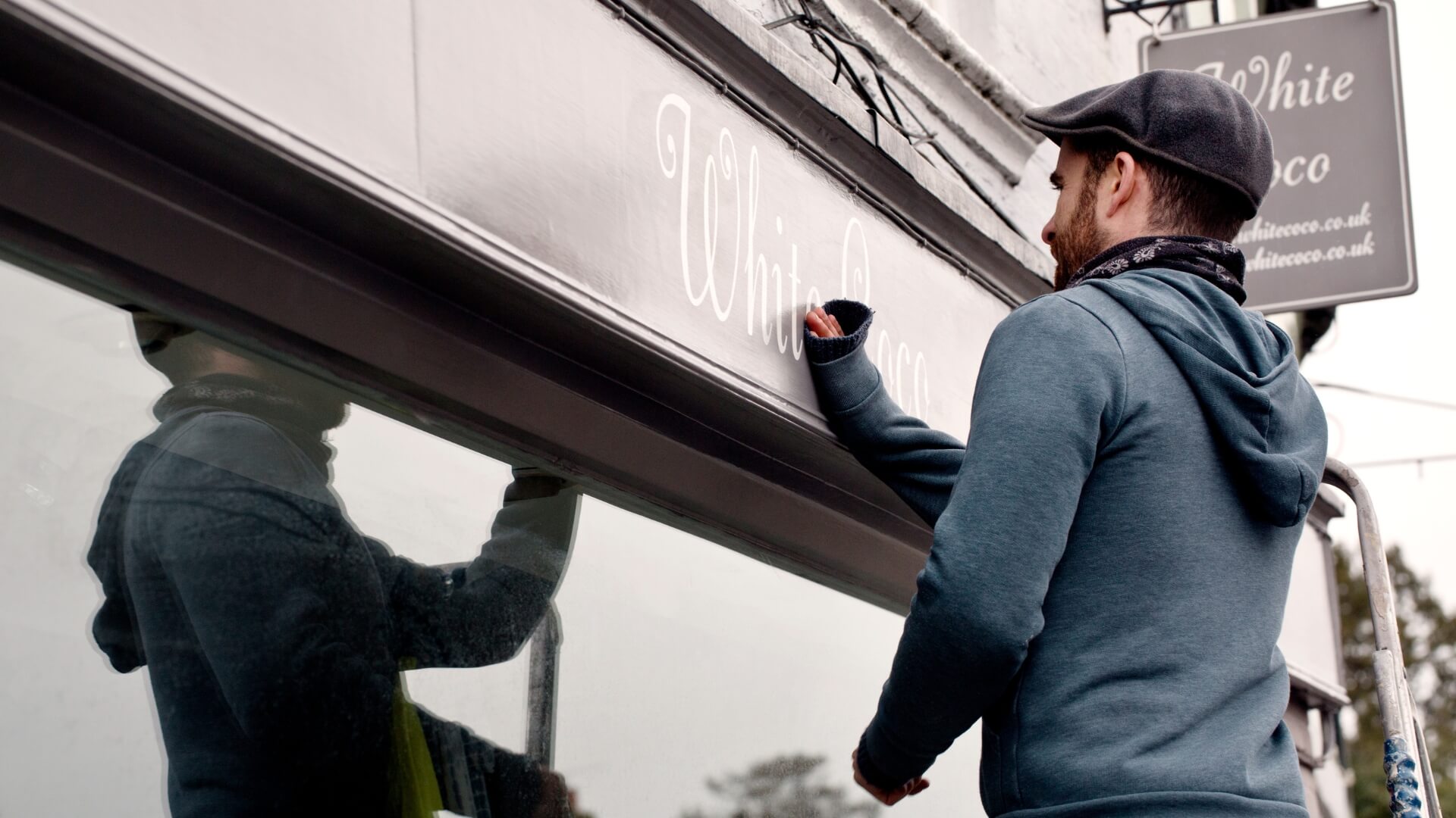 a person cleaning a flat sign board