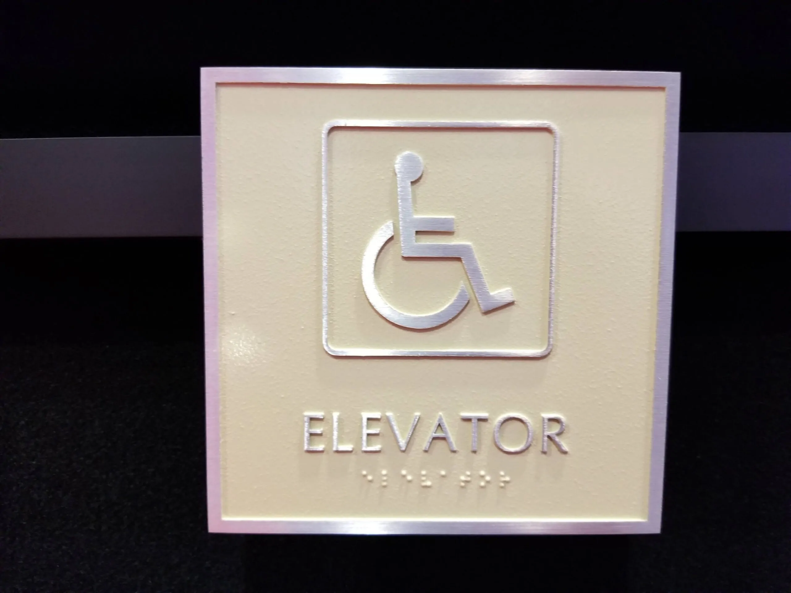ADA elevator sign with tactile braille lettering nyc